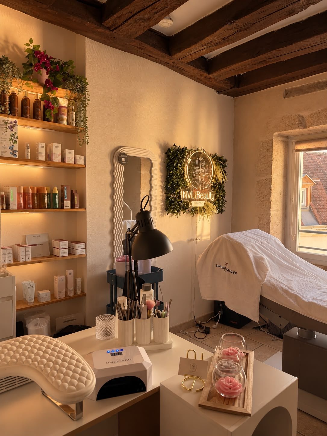 L'institut NVL Beauty baigné de lumière : poutres apparentes, étagères de produits et table de soins